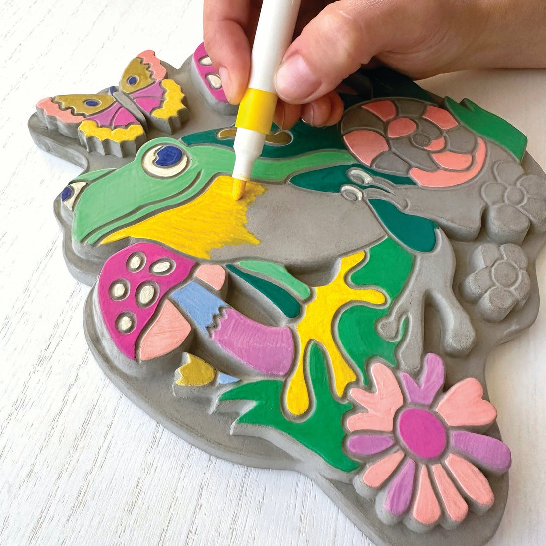 A person coloring the garden stone on a white background.